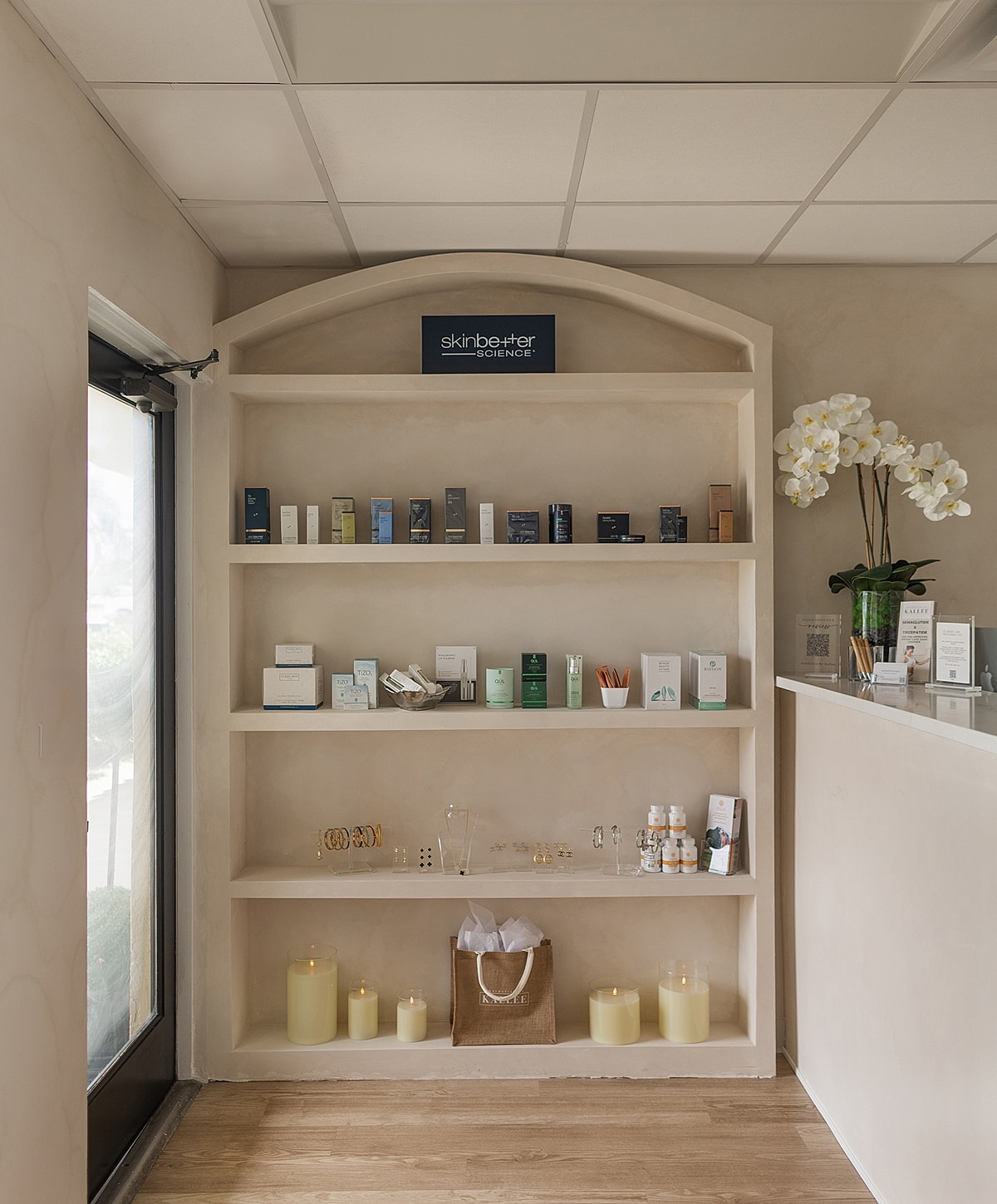 Skin care products displayed on minimalist shelves.
