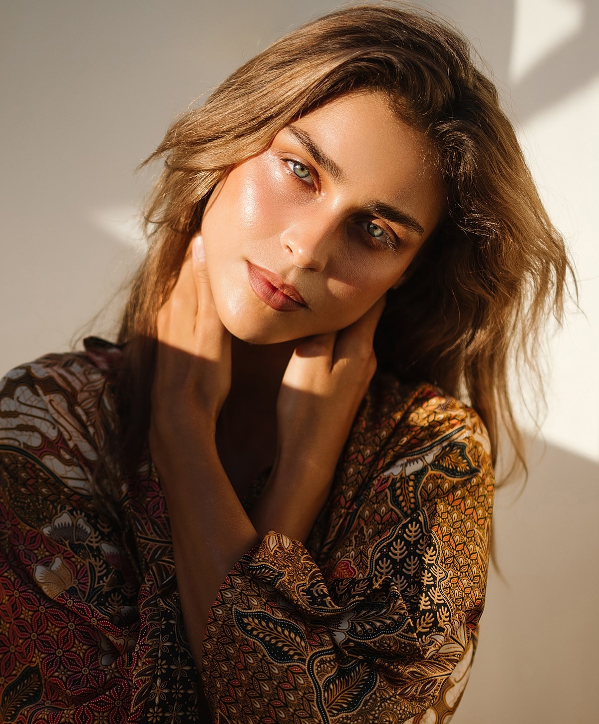 Woman in patterned shawl with natural lighting.