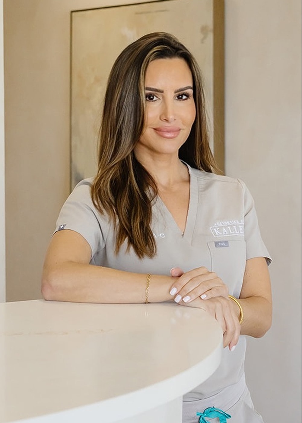 Professional woman in medical attire smiling.