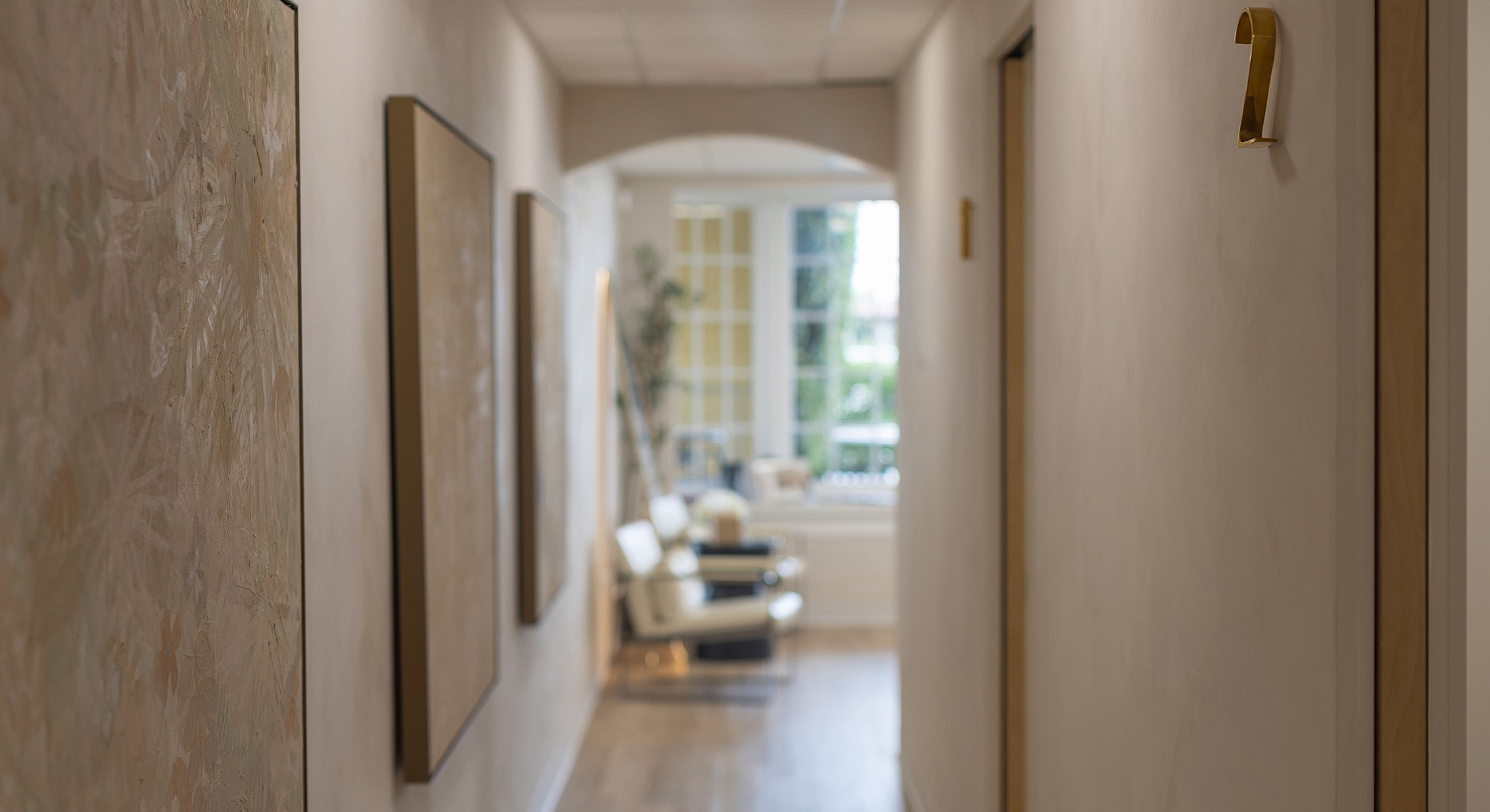 Hallway with artwork and waiting area in background.