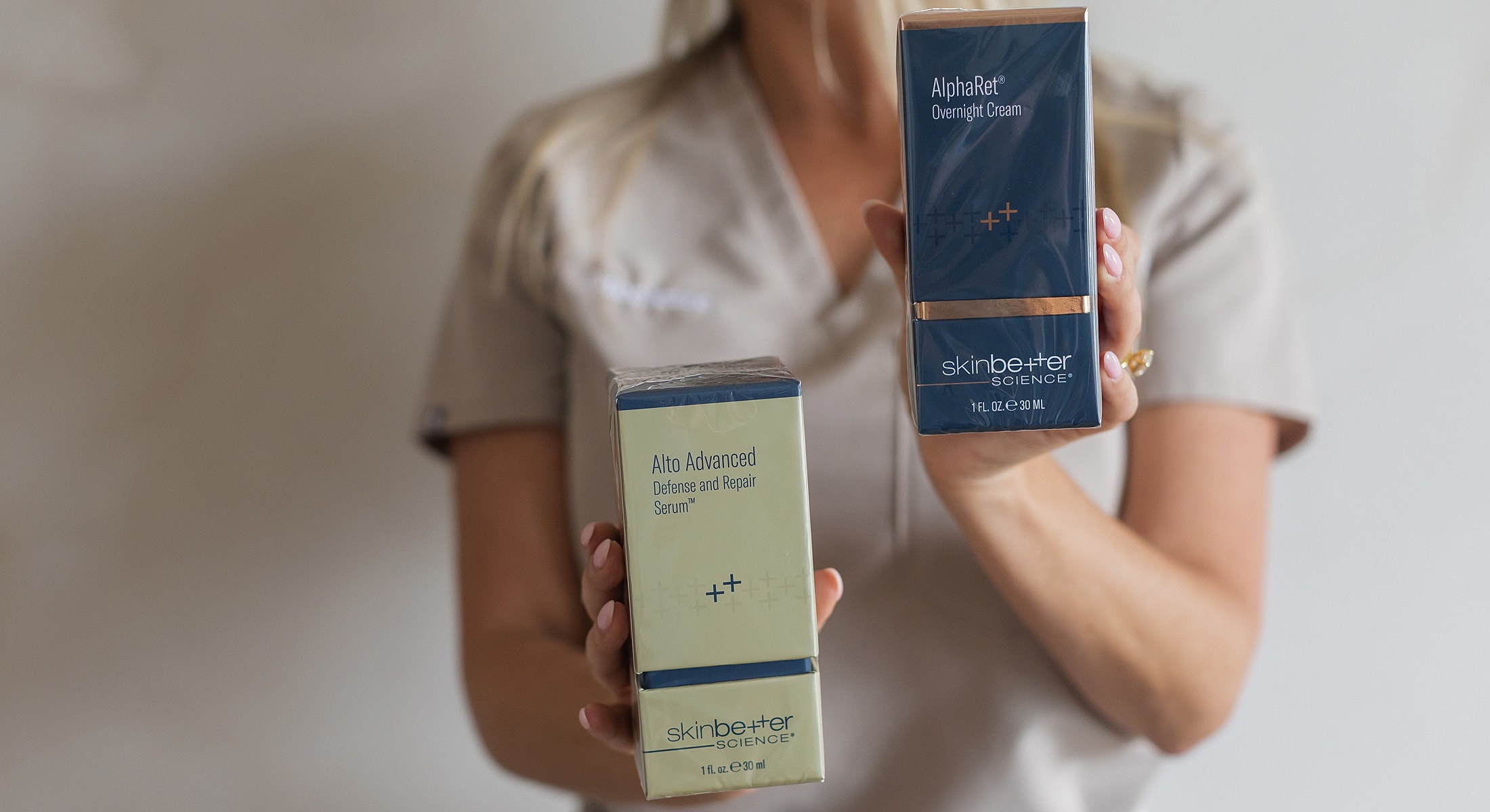 Skin care products held by a person.