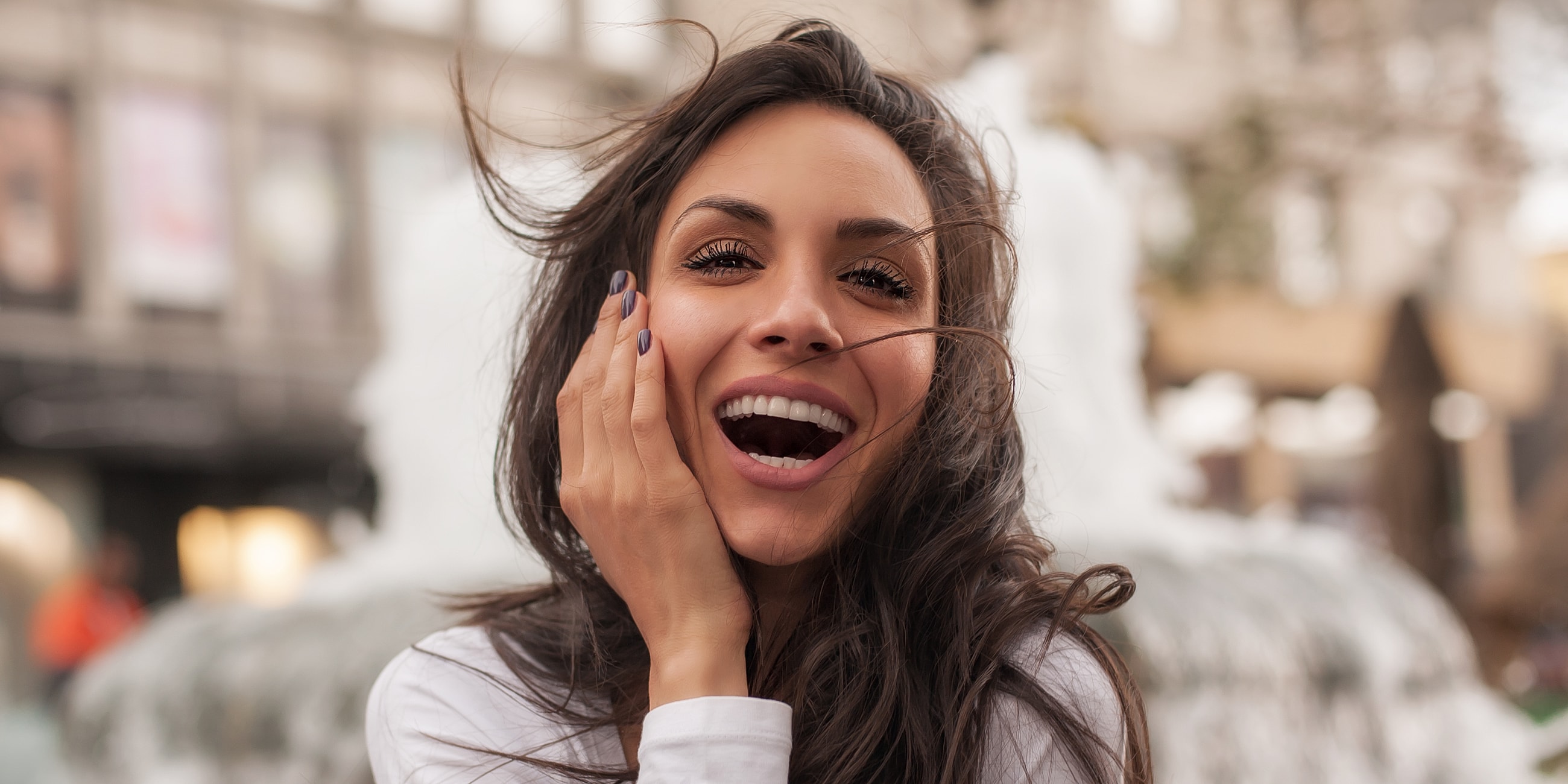 Smiling woman near a fountain outdoors.